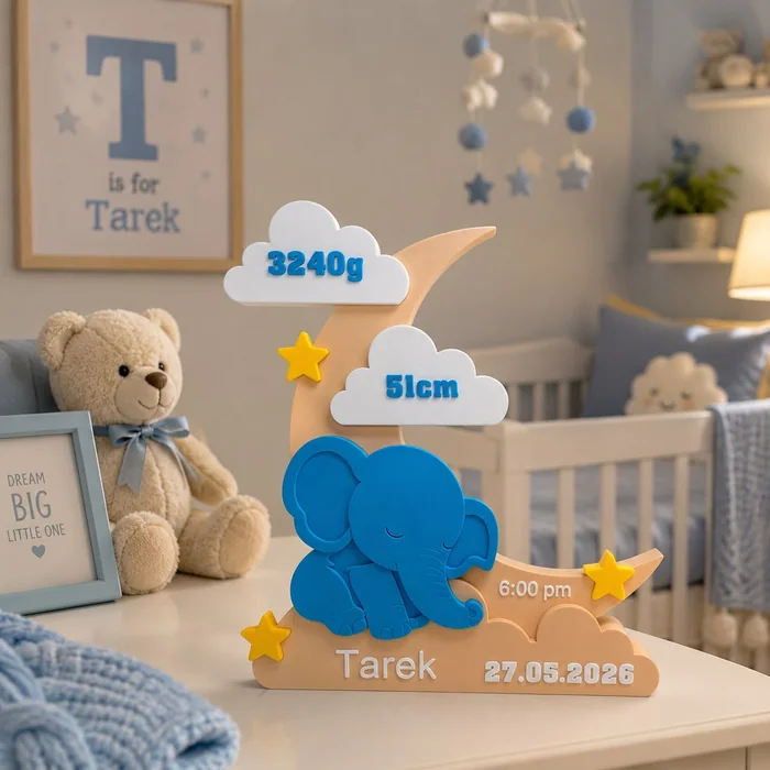 A wooden birth display with a blue elephant, clouds showing weight and length, and a name and date, in a nursery