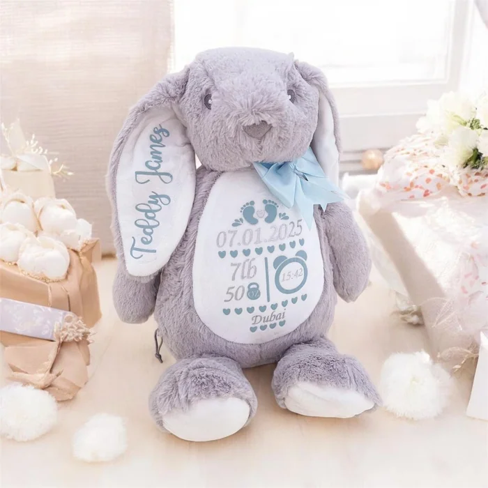 A grey plush bunny embroidered with a baby's name and birth details