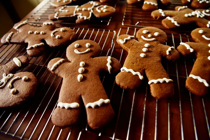 Gingerbread people with white icing smiles cooling on a wire rack