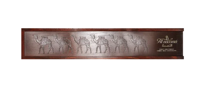 A long wooden box of camel milk chocolates, its lid carved with a line of camels