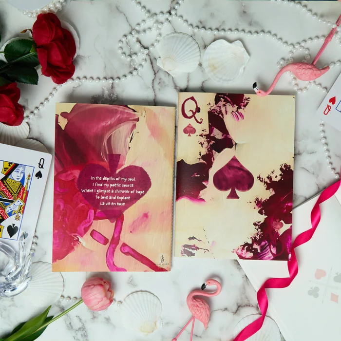 The Queen of Spades vellum notebook, front and back covers in pink and ivory, on marble among roses and playing cards