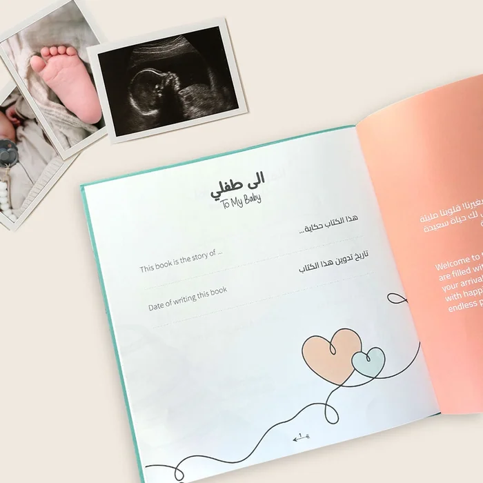 An open bilingual baby book at a To My Baby page, with a scan photo and a baby's foot photo beside it