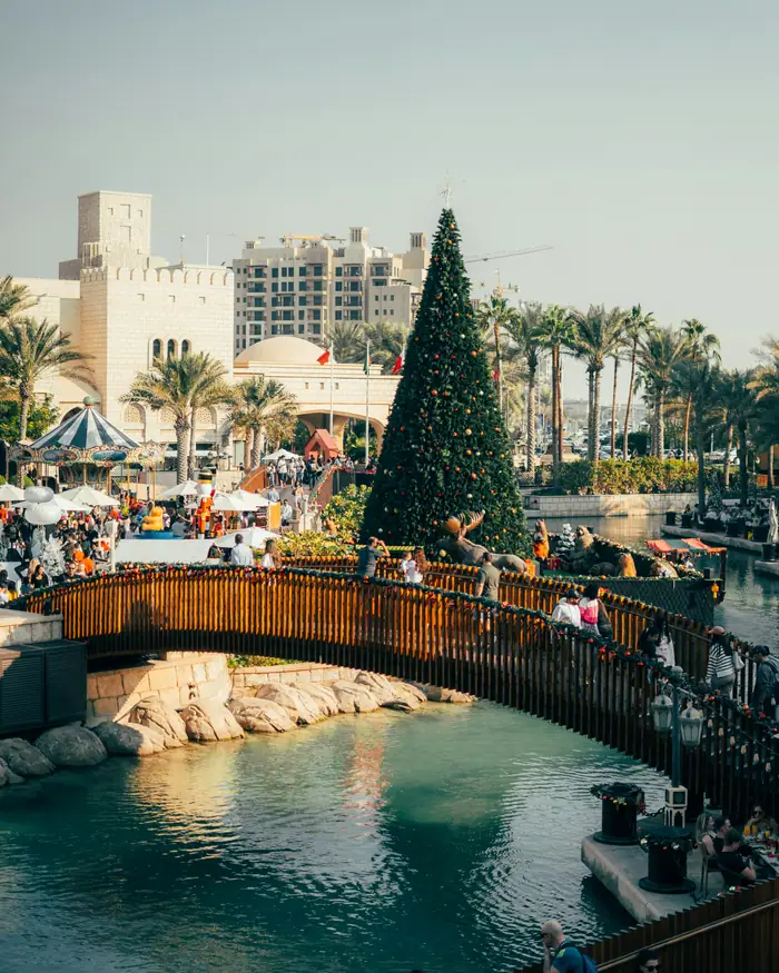 A tall Christmas tree on a wooden bridge over the canal at Madinat Jumeirah