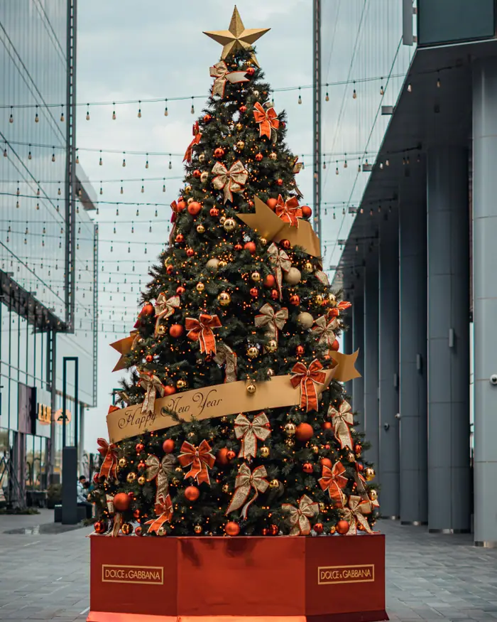 The Burj Khalifa lit up at night behind hanging Christmas decorations in Downtown Dubai