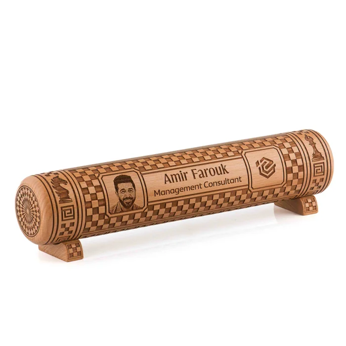 A wooden chess-themed desk piece engraved with a portrait, a name and a job title, on two small feet