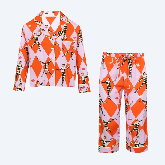 A bright orange and lilac harlequin print pyjama shirt and trousers laid flat