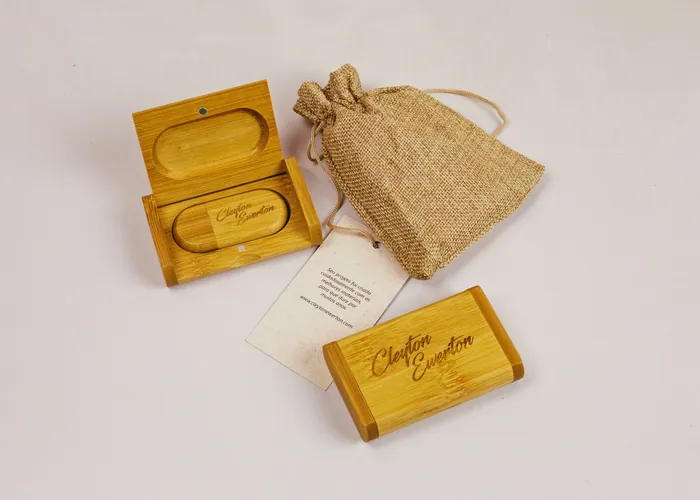 A small bamboo box engraved with a name, beside a linen gift bag and a handwritten card