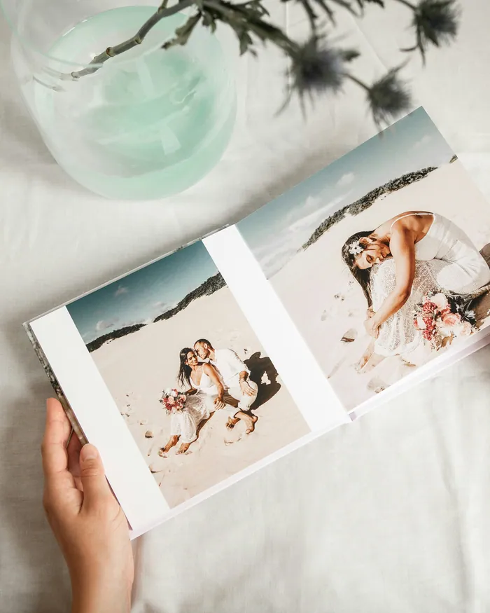 Hands holding open a printed photo book