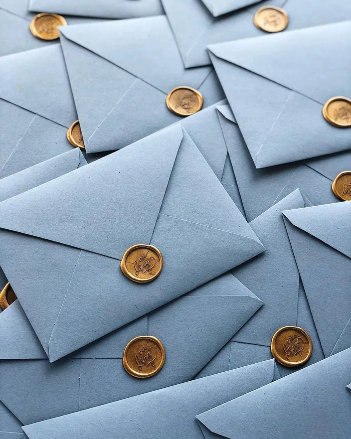Pale blue envelopes sealed with gold wax