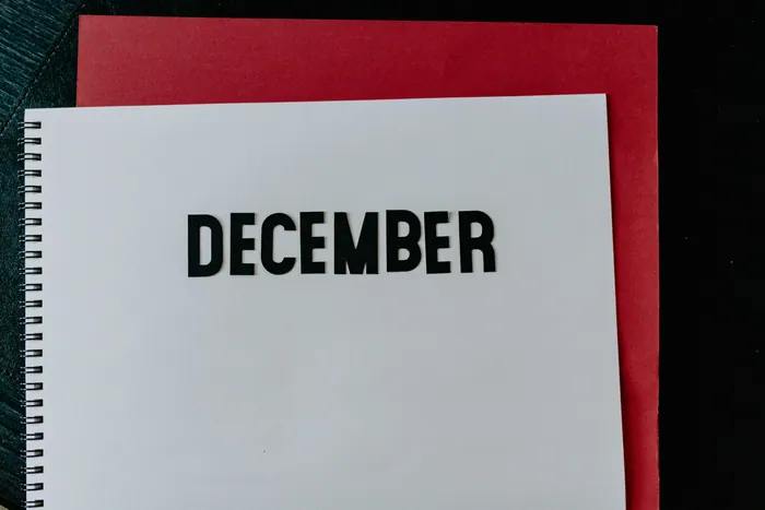 The word December printed in black on a white card against red